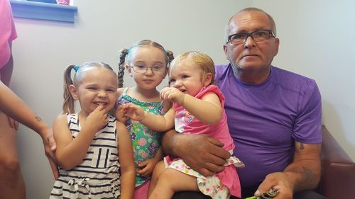 Portrait of grandfather with grandchildren at home