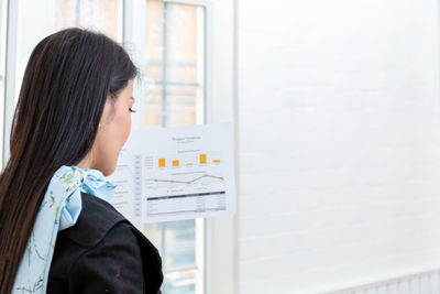 Rear view of woman standing at home