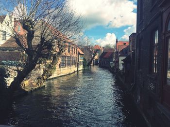 Canal amidst buildings against sky