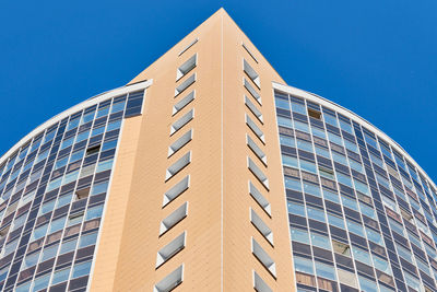 Low angle view of modern building against clear blue sky