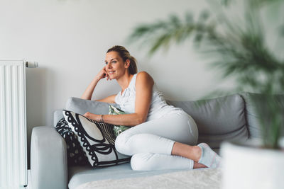 Young woman sitting on sofa at home