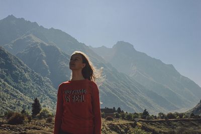 Woman standing on mountain against sky