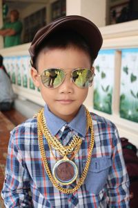 Close-up portrait of boy wearing sunglasses and gold chains