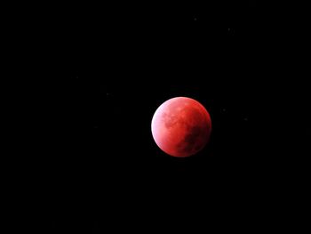 Red moon against clear sky at night