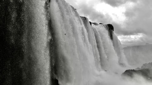 Scenic view of waterfall against sky