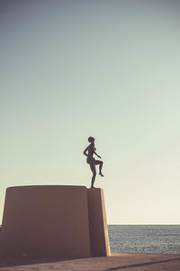 Man standing by sea against clear sky