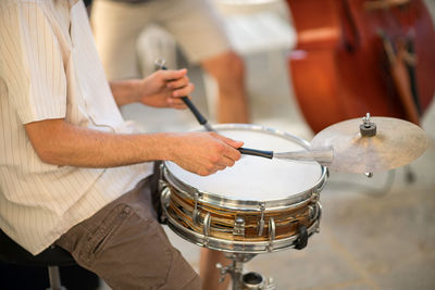 Midsection of man playing drum