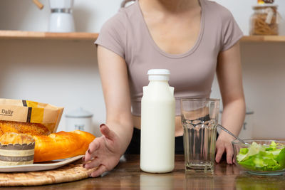 Midsection of woman having food on table