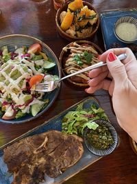 High angle view of hand holding food on table