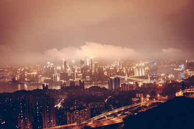 High angle view of illuminated buildings against sky at night