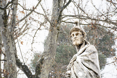 Low angle view of statue against bare trees