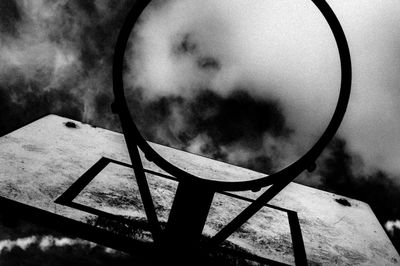 Close-up of metal grate against cloudy sky