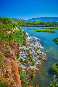 Scenic view of lake against clear blue sky