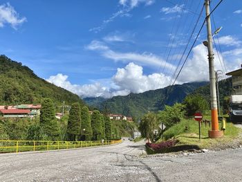 Road amidst plants and mountains against sky