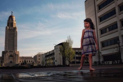 Girl standing against nebraska state capitol building 