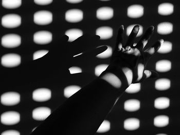 Sunlight falling on woman hand against wall