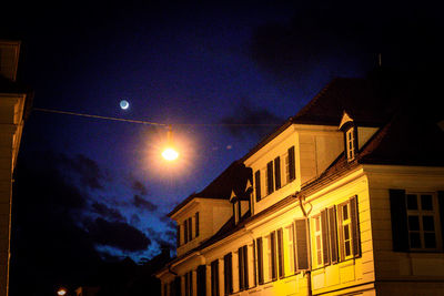 Low angle view of illuminated buildings against sky at night