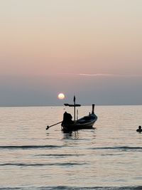 Silhouette boat in sea against sky during sunset