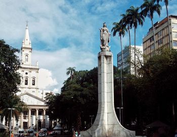 Low angle view of clock tower against cloudy sky