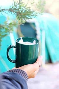 Close-up of hand holding coffee cup