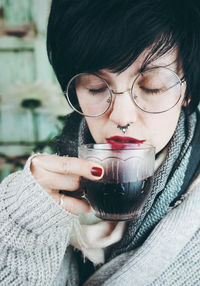 Close-up of mid adult woman drinking coffee at home