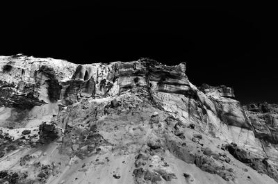 Low angle view of rock formation against sky during winter