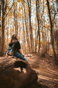 Woman sitting on rock in forest