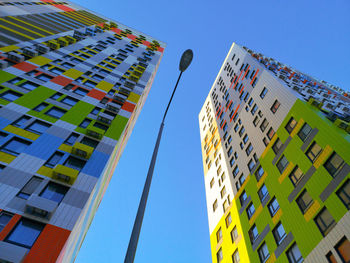 Low angle view of modern buildings against blue sky