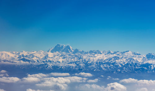 Scenic view of snowcapped mountains against blue sky