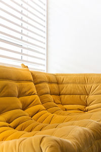 Close-up of sofa against window blinds at home