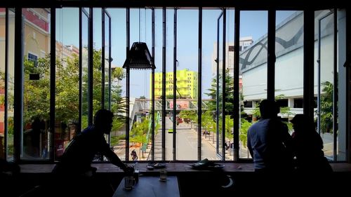 Rear view of a woman sitting in window