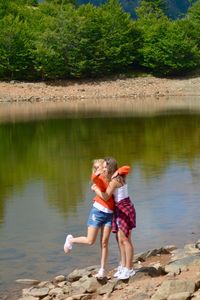 Rear view of mother and daughter in lake