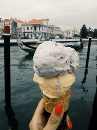 Cropped hand of woman holding ice cream cone against grand canal