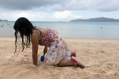 Woman at beach against sky