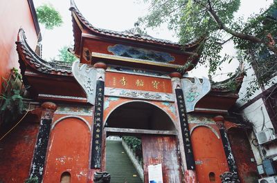 Low angle view of temple amidst buildings and trees