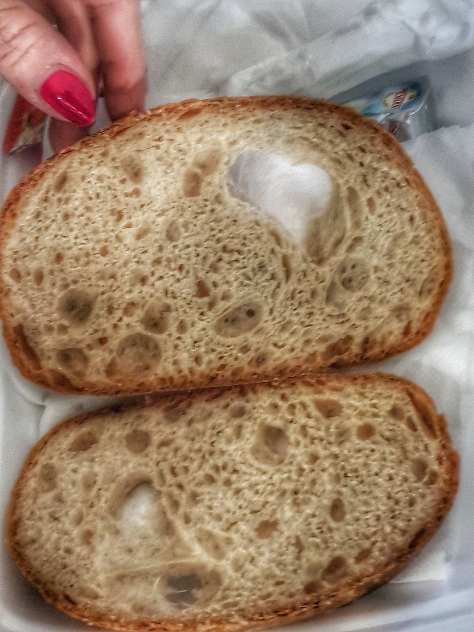 HIGH ANGLE VIEW OF HAND HOLDING BREAD IN CUP