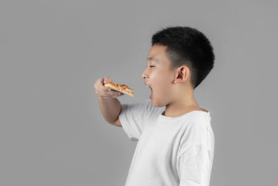 Boy holding ice cream against white background