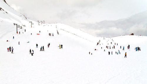 People flying against sky during winter