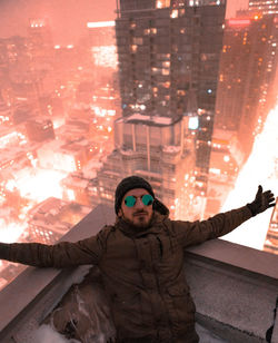 High angle view of man on building terrace in city during winter at night