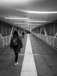 Rear view of woman walking in tunnel