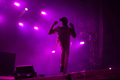 Man with arms outstretched standing at night