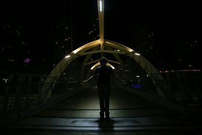 Rear view of people walking on footbridge