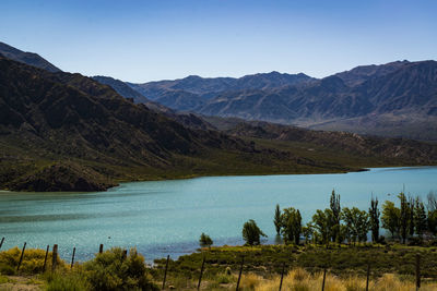 Scenic view of lake and mountains against clear sky