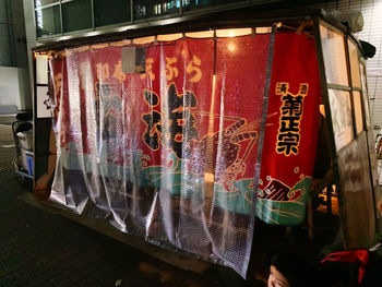 Clothes hanging on glass for sale at market stall