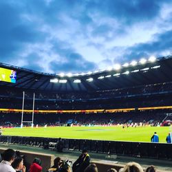 People looking at soccer field against sky