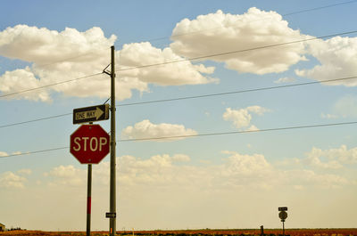 Low angle view of road sign against sky