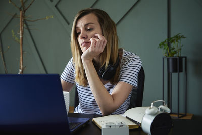 Exhausted woman at home office workplace using laptop