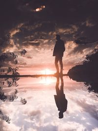 Silhouette man reflecting at beach against cloudy sky during sunset