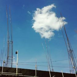 Low angle view of electricity pylon against blue sky