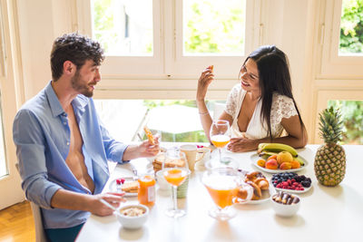 Couple eating food while sitting at home